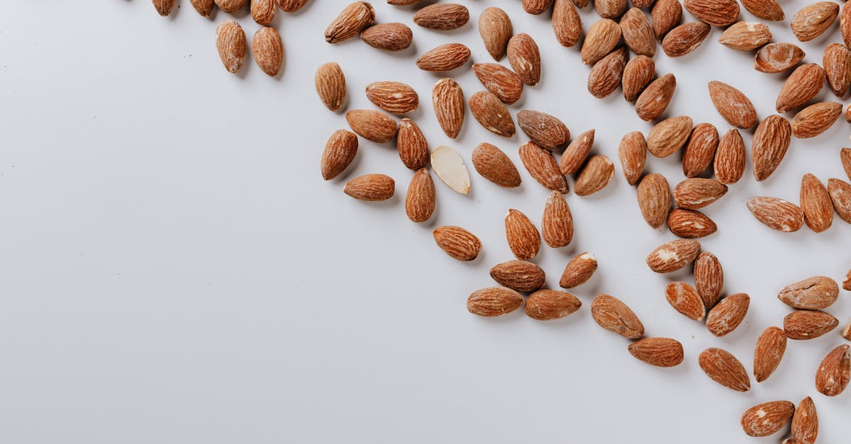 separating almond flour from almond meal - Top view of delicious and nutrition almond cluttered on white table illustrating healthy food eating concept