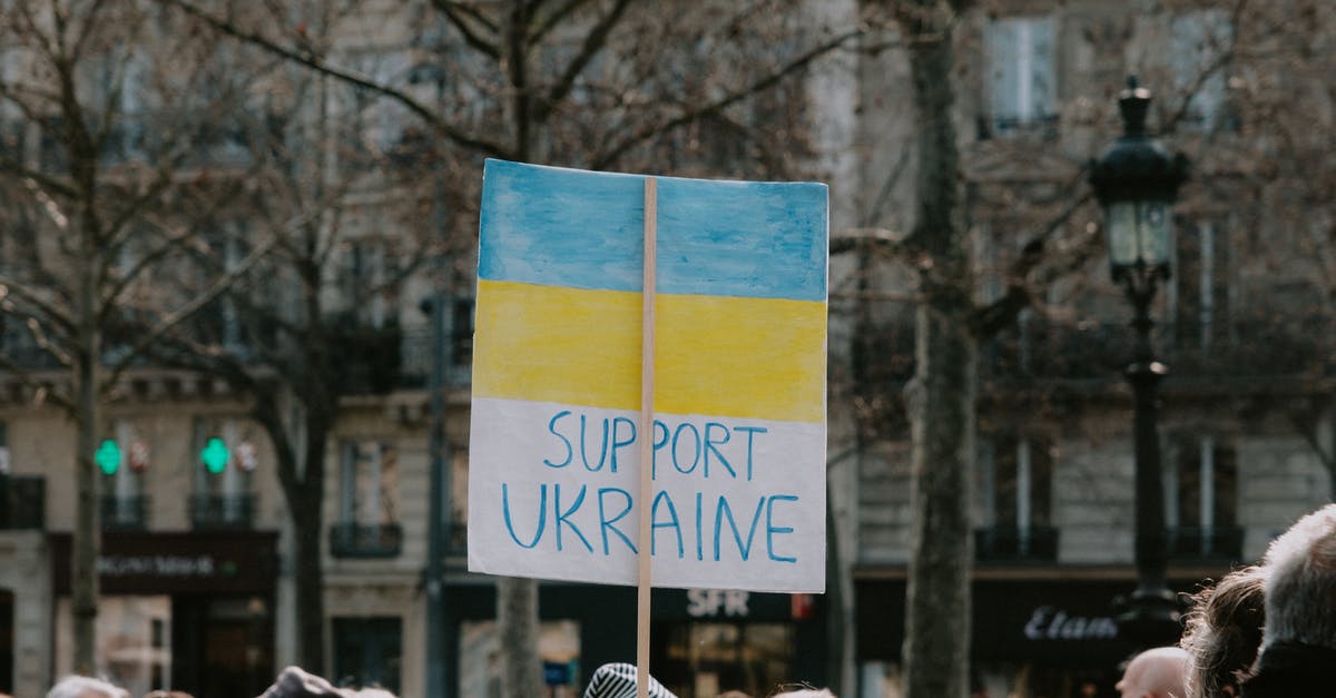 Serving Creme Brulee to a large group of people - Large Group of People Holding Banner on Supporting Ukraine