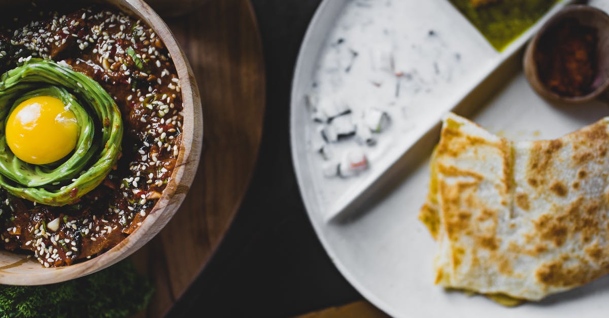 Sesame Seed replacement - From above of bowl with miso eggplant and avocado decorated with sesame seeds and placed near plate with delicious snacks