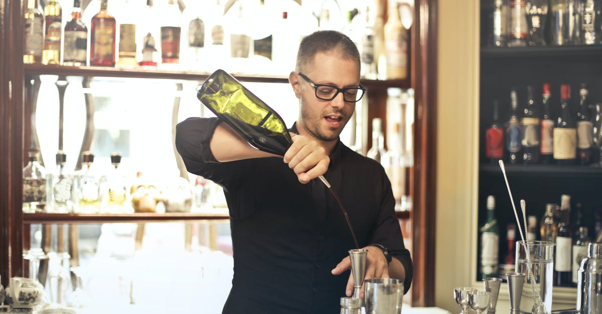 Shaking cocktails without bar equipment - Barman preparing cocktail at counter