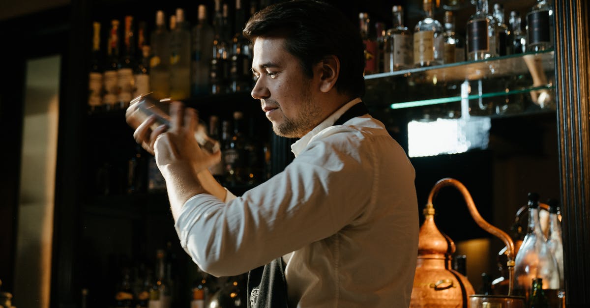 Shaking cocktails without bar equipment - Man in White Dress Shirt Holding Bottle