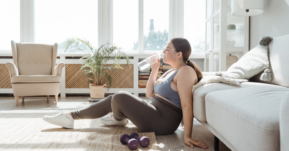 Should I be concerned about drinking tap water? - Woman in Blue Tank Top and Black Shorts Sitting on White Couch