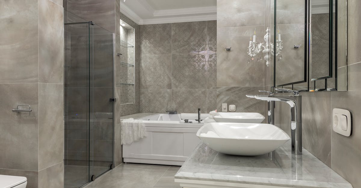 Should I buy steel or ceramic knives? - Luxury interior of spacious bathroom with tiled walls and floor double vessel sink vanity and chandelier