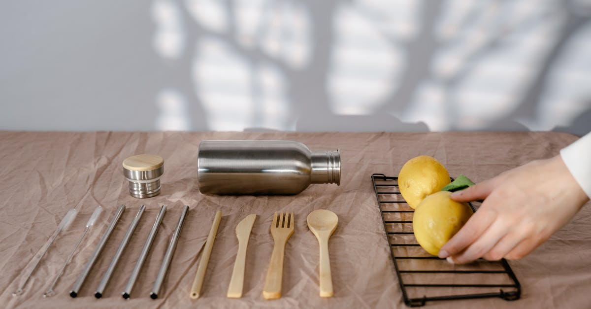 Should I maintain a carbon steel knife with oil? - A Person Holding a Lemon on a Table with Utensils and Tumbler