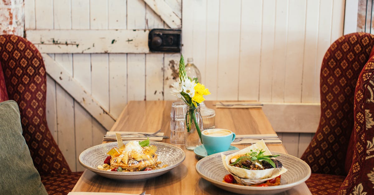 Should I rest pancake batter? - Delicious meals of pancakes with fruits and salad in pita bread with cup of coffee and glass of water on wooden table near big burgundy armchairs