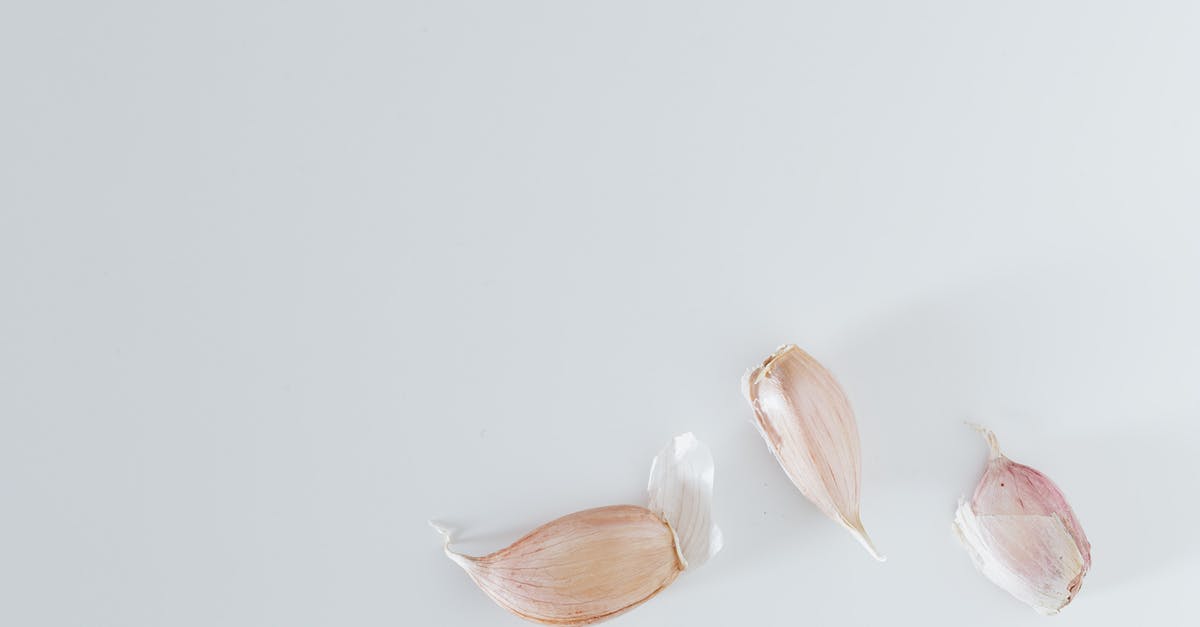 Should one always use the whole garlic clove? - Minimalistic composition of unpeeled garlic on gray surface