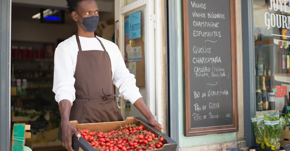 Should tomatoes be stored in the fridge? - A Man Holding a Crate with Tomatoes