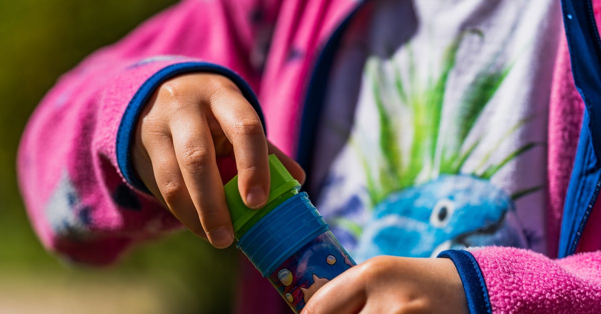 Simmering with or without the lid - Person in Pink and Blue Long Sleeve Shirt Holding Green and Blue Plastic Bottle