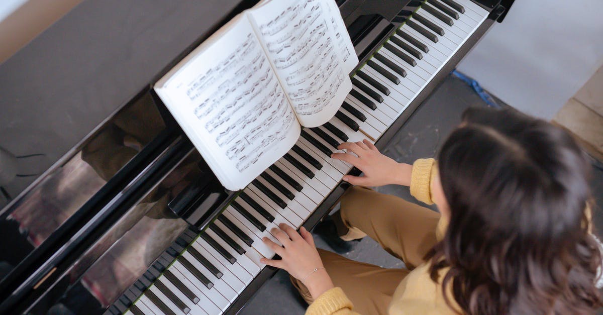 Skills that are only learned by professional chefs? - From above of crop faceless woman in warm yellow sweater with music book practicing music on piano in light classroom