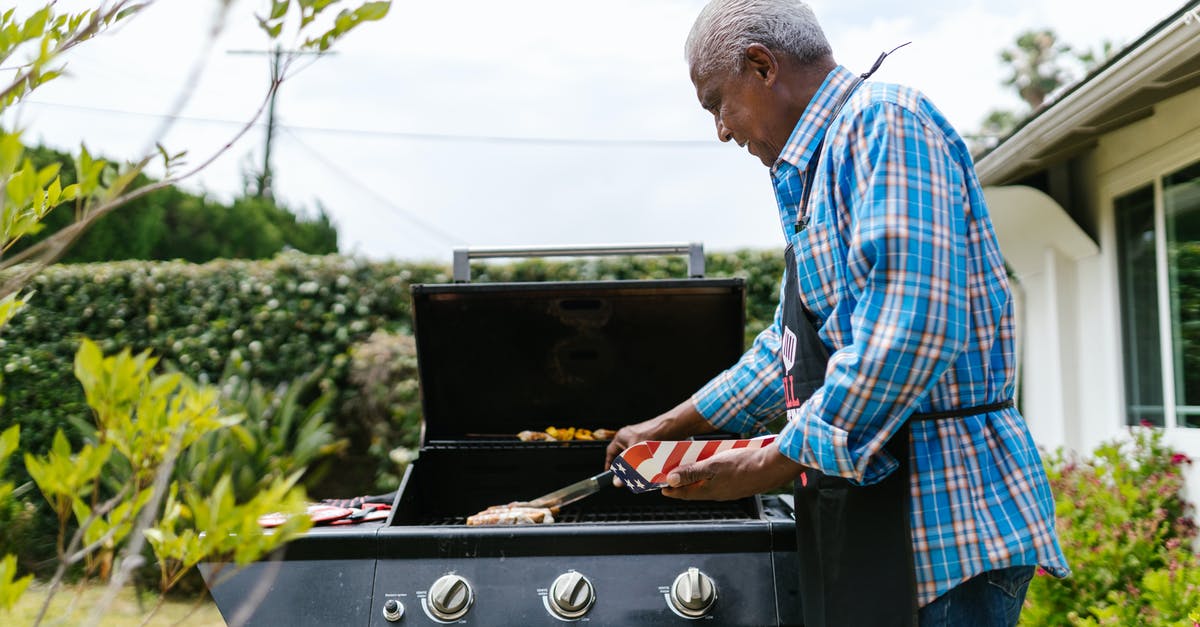 Slicing bratwurst for quicker, more even grilling - Elderly Man Putting Hotdogs on a Griller