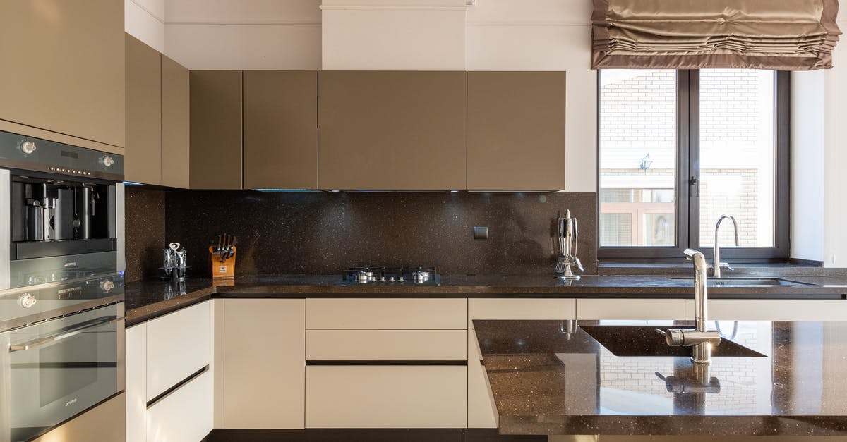 Slow oven brown rice - Table with tap placed in modern spacious kitchen with window and brown cupboards and contemporary appliances and various utensils at home