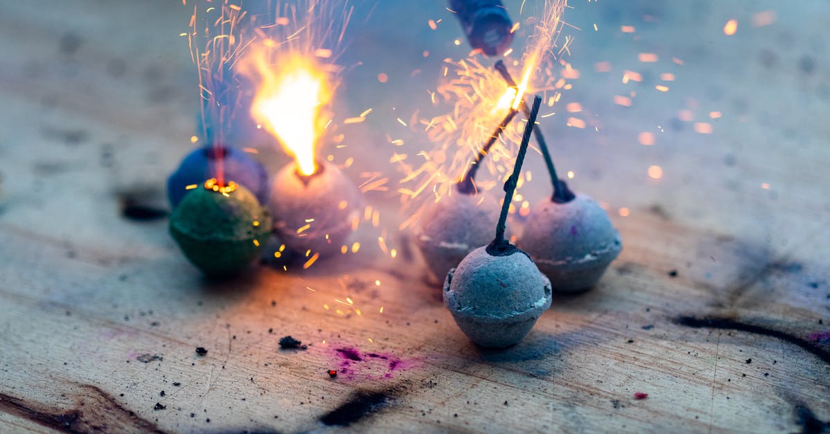 Slowing motor and electric smoke coming from Magic Bullet blender? - From above sparkling glowing Bengal candles with bright sparks burning on weathered wooden surface