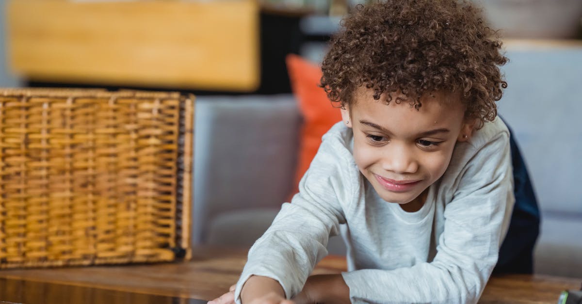 Small baskets for fries - Ethnic child in casual clothes leaning forward table and touching surface and looking down