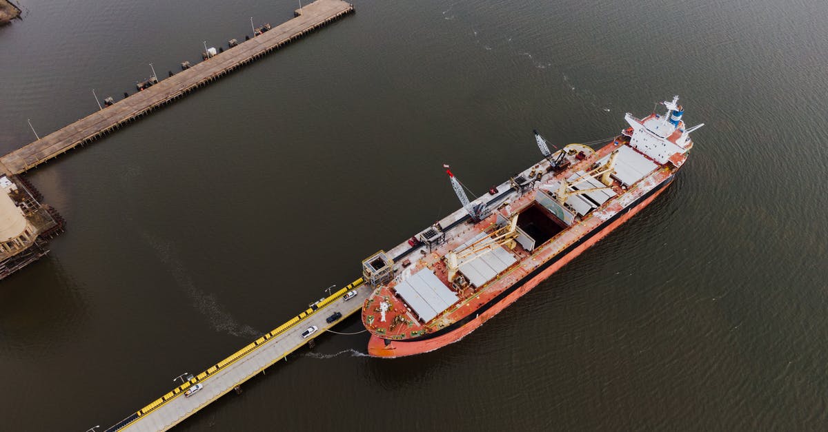 Smart ways to clean a greasy metal vessel? - Drone view of metal ship with cargo on peaceful rippling water of river in daytime