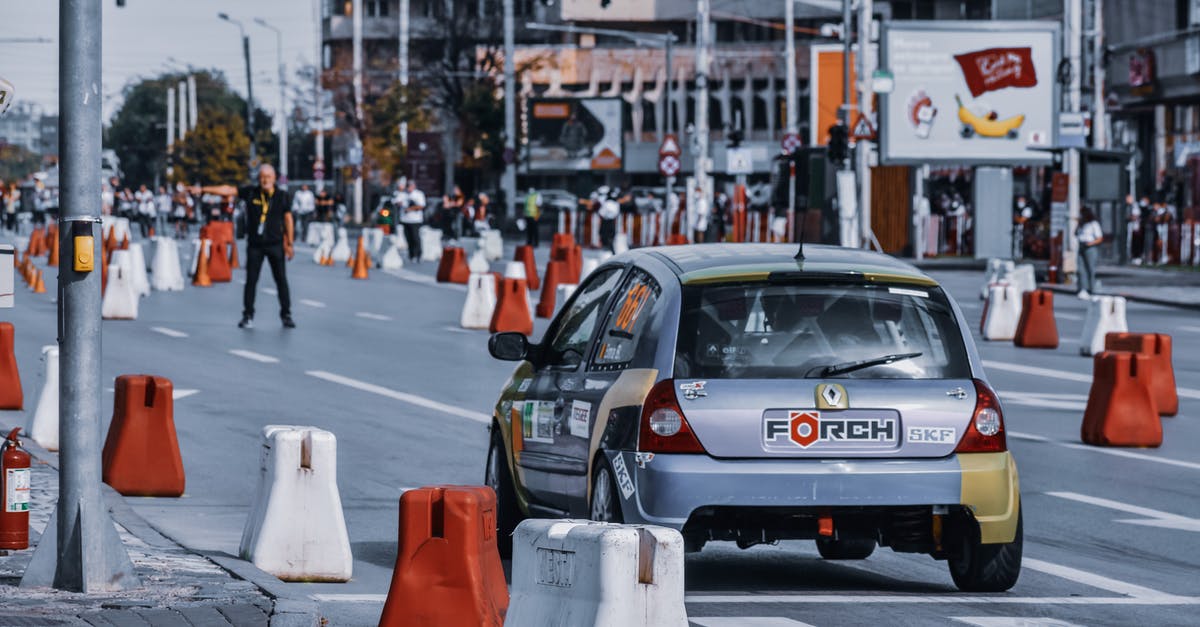 Smart ways to clean a greasy metal vessel? - Modern automobile driving on asphalt road with barriers in street of contemporary town