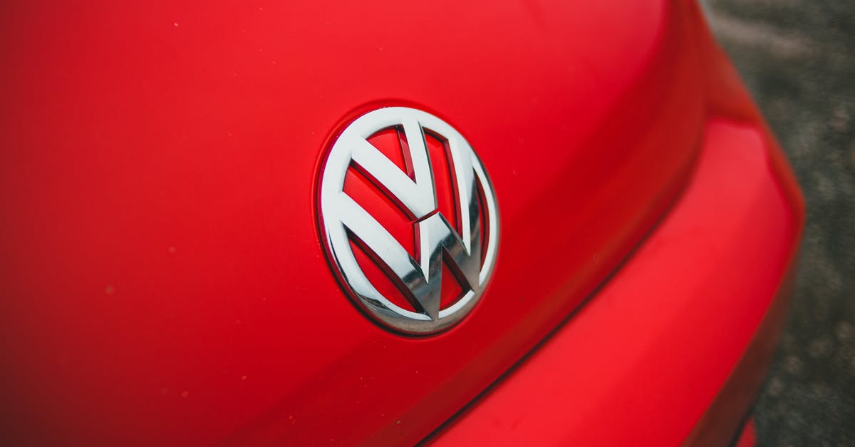 Smart ways to clean a greasy metal vessel? - From above bright bonnet of contemporary red automobile with silver logotype parked on asphalt road on street of city