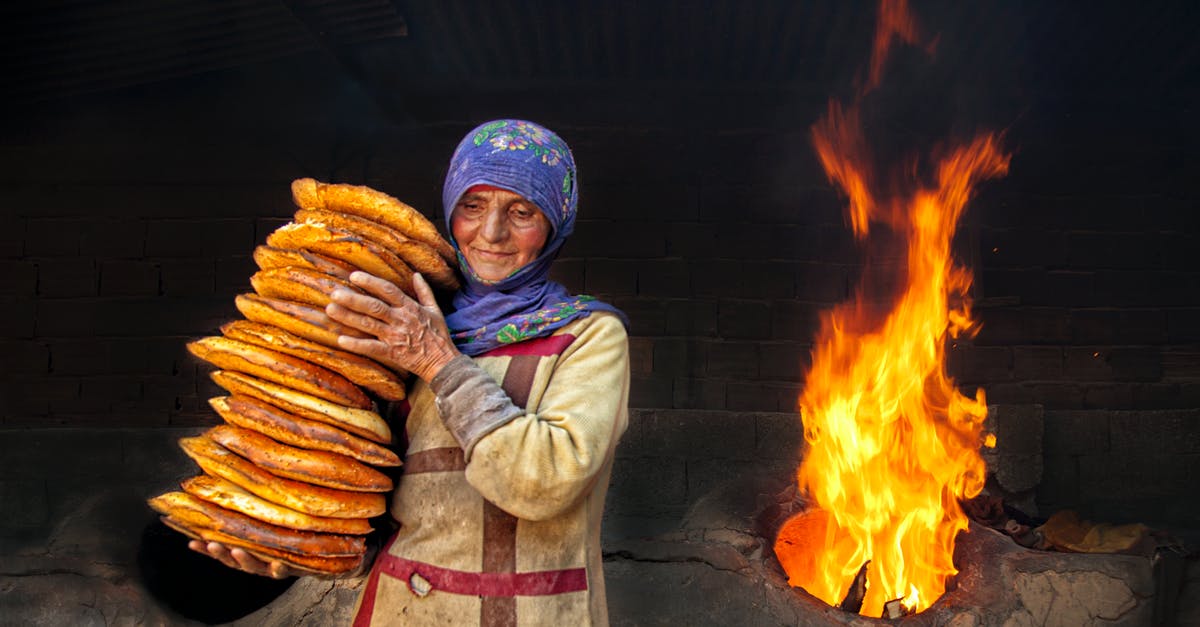 Smoke coming from oven - An Elderly Woman Carrying a Stacked of Flatbread