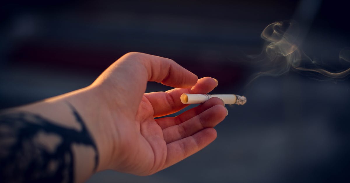 Smoking chicken breasts with and without skin - Close-Up Photography of a Person Holding Cigarette