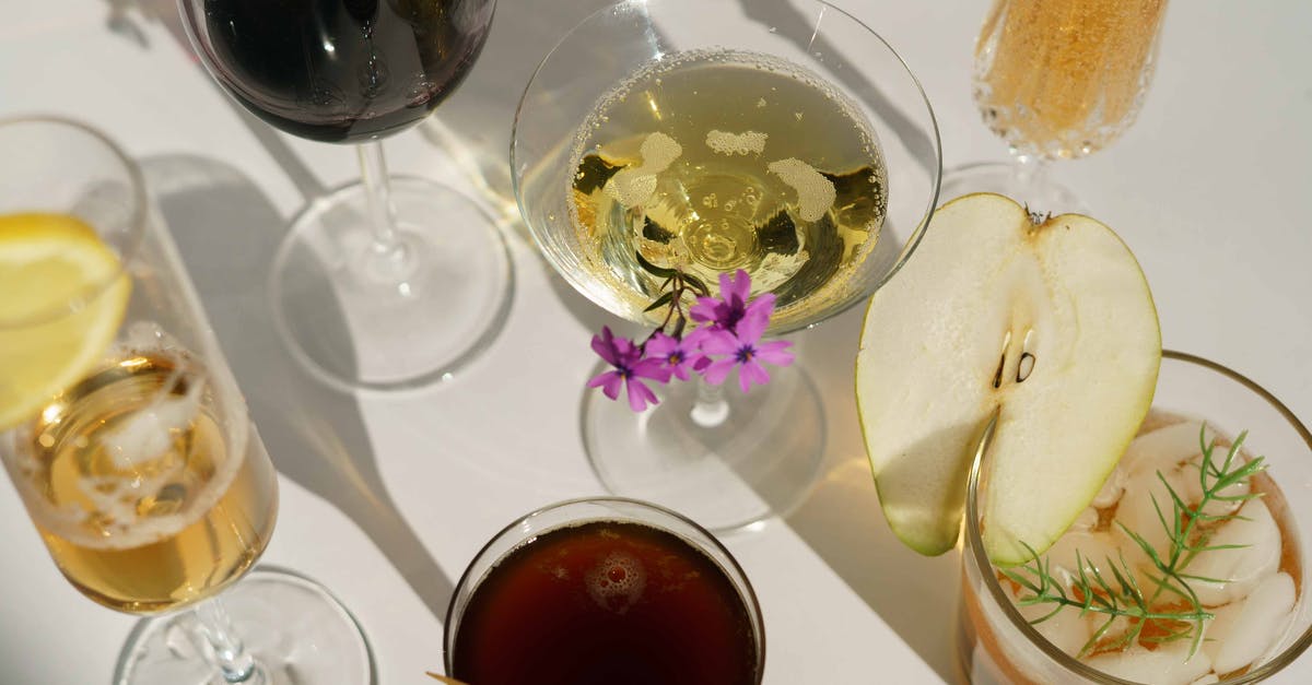 Soaking fruit in alcohol - Glasses of cocktails decorated with pear and blooming flowers