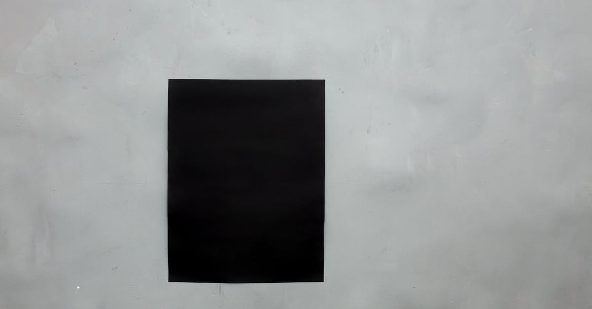 Something dark gray coming off of sheet pan after scouring - Rectangular creative black mock up poster with copy space hanging on empty gray wall in light room of modern studio