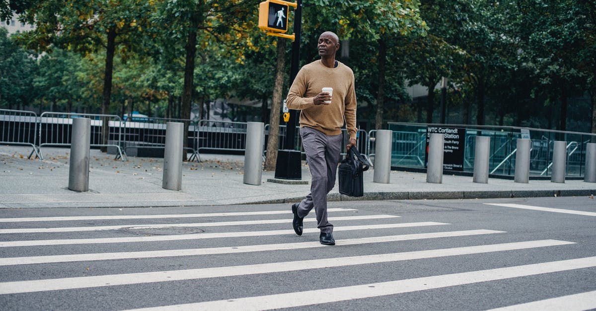 Sourdough teacakes/hot cross buns? - Full body of African American male walking on pedestrian crossing on asphalt road with cup of hot drink and briefcase
