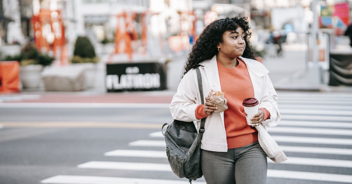 Sourdough teacakes/hot cross buns? - Friendly black woman with takeaway coffee crossing road in city