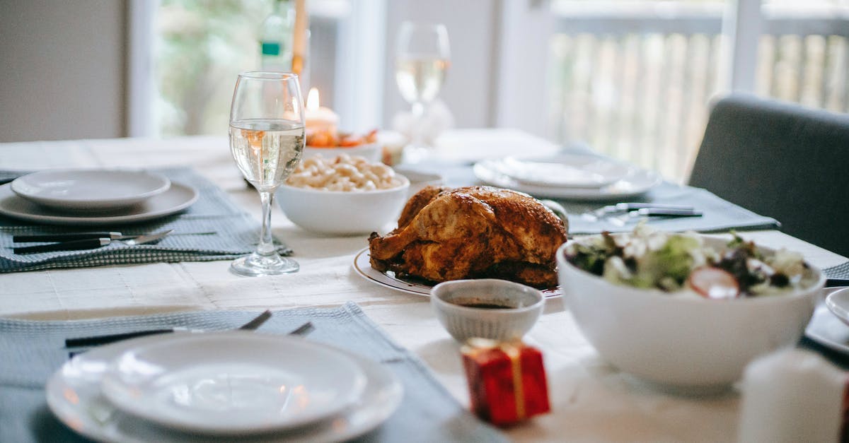 Spatchcock Turkey in Small Oven - Banquet table with delicious roasted turkey and vegetable salad near dishware during New Year holiday in house