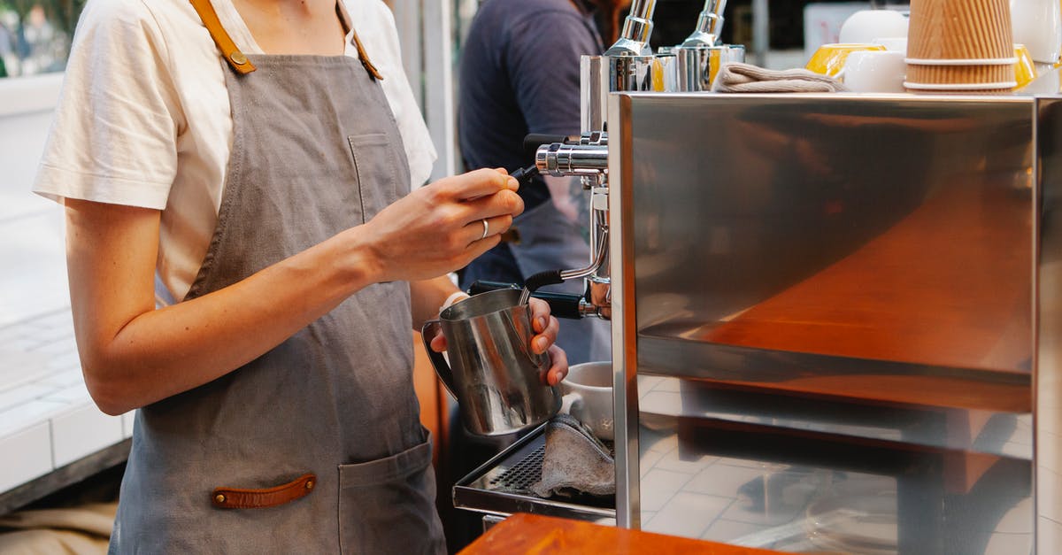 Special coffee served in Malaysia (or India) - Crop anonymous female in apron making hot coffee with special coffee machine in kitchen of cafe