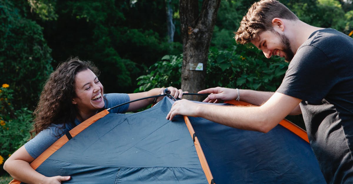 Spice Mixture for a Hiking Trip [closed] - Cheerful young couple in casual clothes laughing while setting up camping tent during romantic picnic in nature