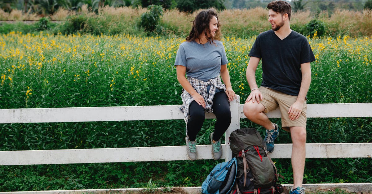 Spice Mixture for a Hiking Trip [closed] - Romantic young couple resting on wooden fence near blooming lush meadow and chatting during hiking trip in countryside