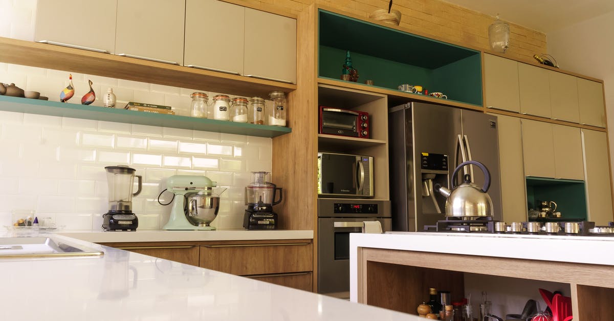 Spots in Stainless Pots after cleaning in self cleaning oven - Low angle of modern kitchen interior with spacious cabinets and contemporary appliances in sunlight