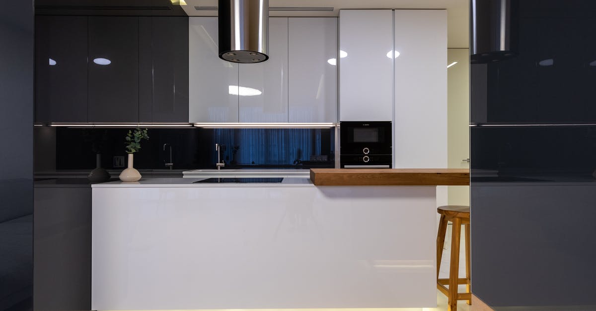 Spots in Stainless Pots after cleaning in self cleaning oven - Interior of stylish kitchen with counter and appliances with cabinets glossy reflecting surface