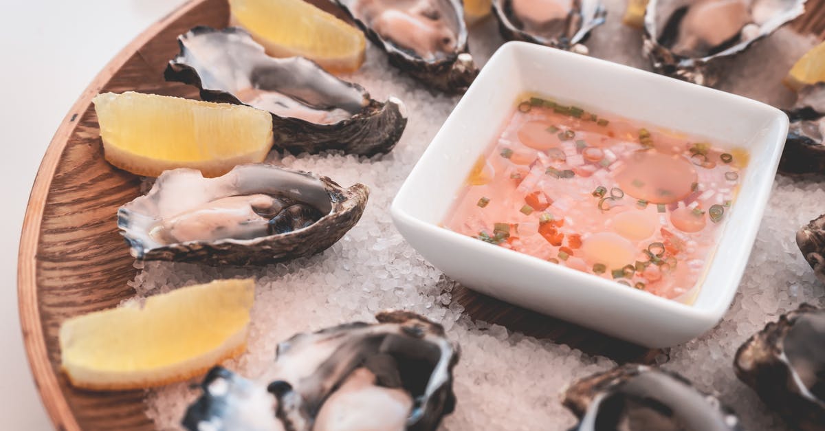 Spotting frozen seafood in restaurants - Delicious oysters with lemons and sauce served on ice