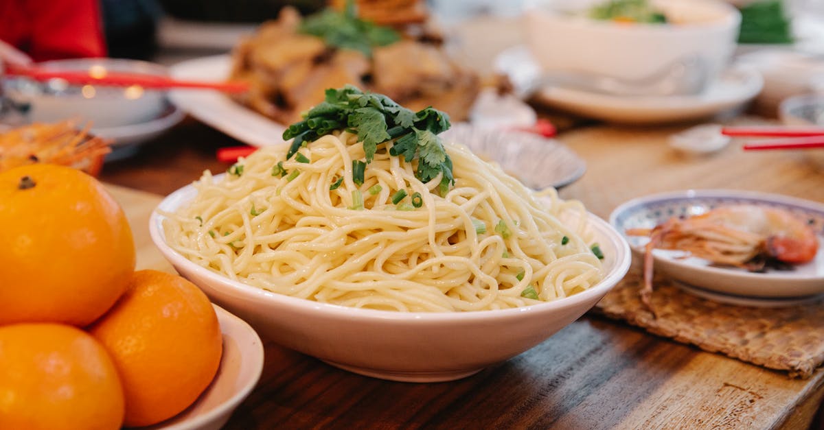 Spring onion (green onion/scallion) in coq au vin? - Tasty cooked noodles with fresh parsley leaves between prawn and ripe oranges on table in house