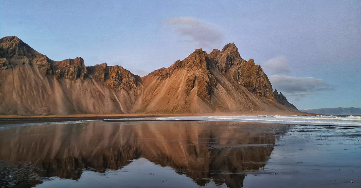 Spring rolls splitting when frozen - Calm sea water with melting ice near mountains