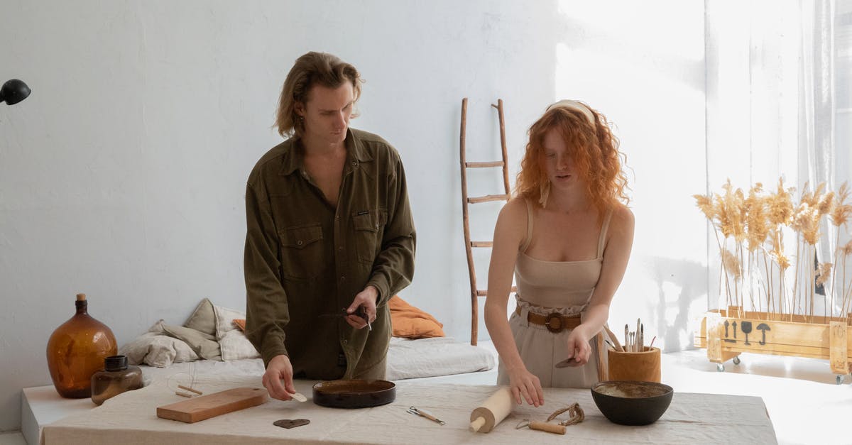 Standing Rib Roast - Young man with female partner in casual clothes preparing pottery tools at table in workroom