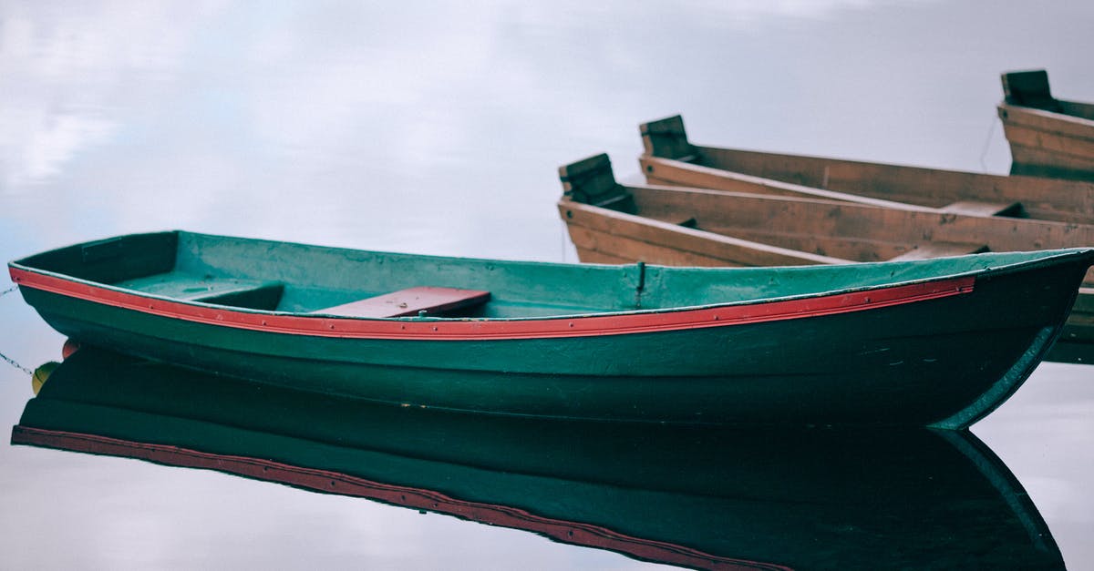 Starch accumulating as sediment during shallow fry - Wooden boats moored on calm pond water