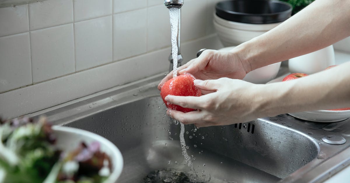 Starter with water, flour, grated apple - Person Washing a Fruit From a Faucet