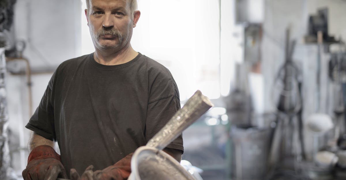 Steaks look light brown aren't charing - Male metallurgist working with metal in workshop