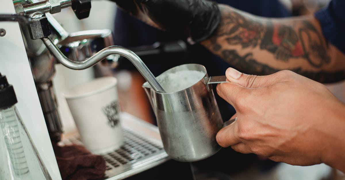 Steam "nature" of cappuccino steamers - Crop faceless barista frothing milk with steam wand