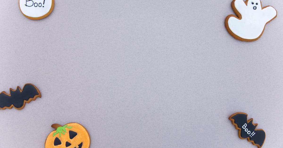 steam vs. bake a sugar pumpkin - Top view of assorted gingerbread cookies with icing in different Halloween decoration shapes arranged on gray surface as frame