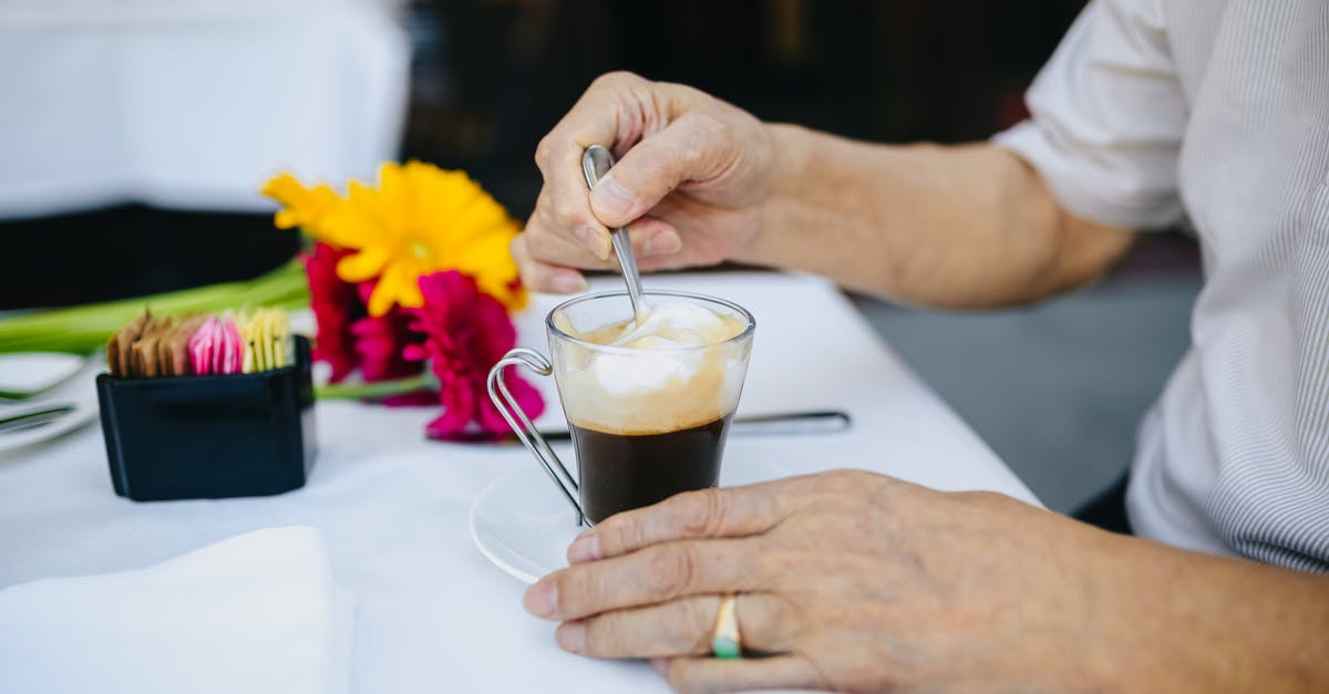 Stirring with knives? - Person Holding Clear Drinking Glass With Black Liquid