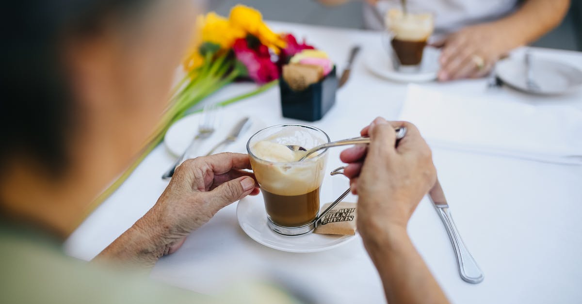 Stirring with knives? - Person Holding Clear Drinking Glass with Coffee