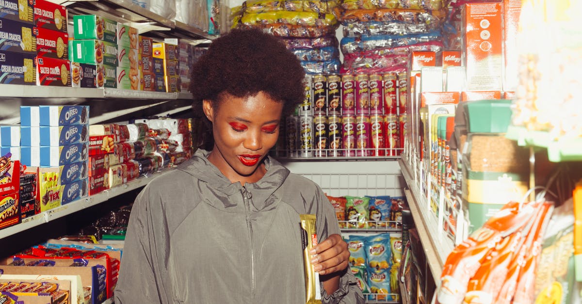 Storing chocolate - Positive ethnic woman choosing food in grocery store