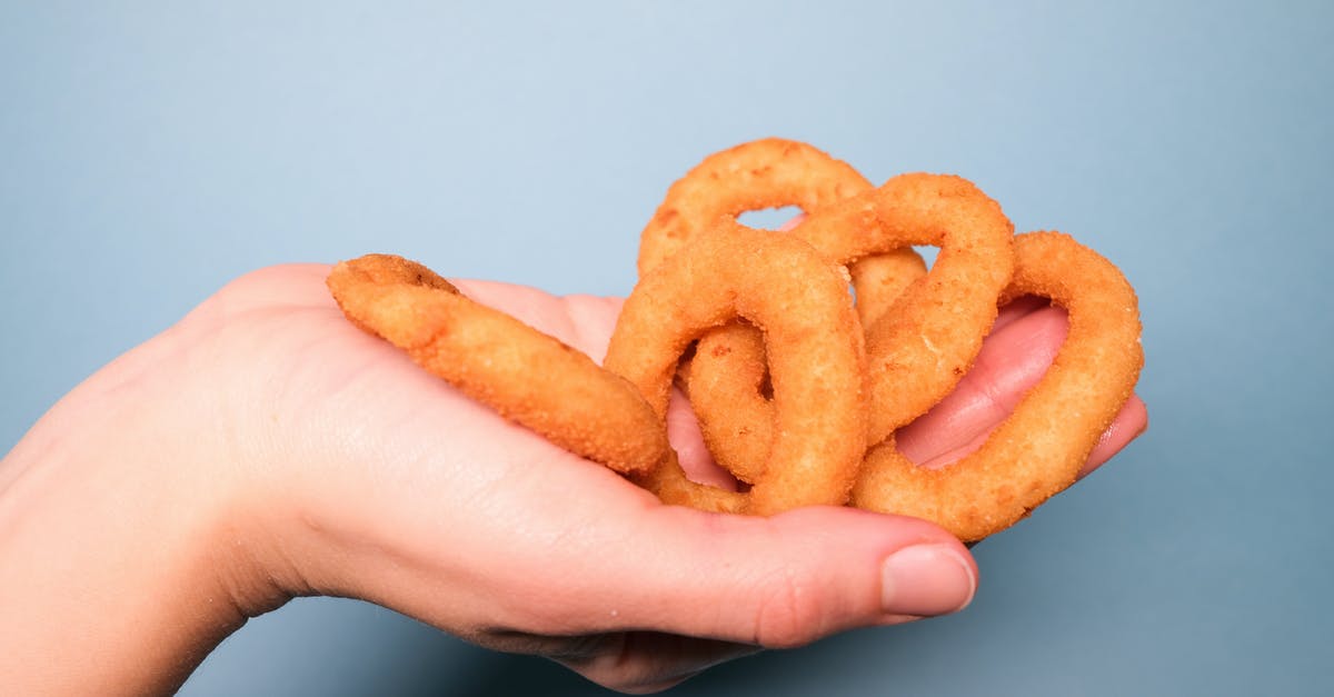 storing crispy fried onions - Faceless person with deep fried onion rings in hand storing crispy fried onions - Faceless person with deep fried onion rings in hand