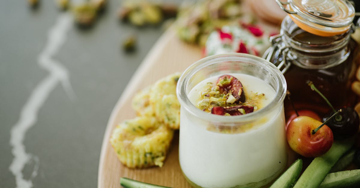 Storing simple syrup [duplicate] - High angle of delicious yogurt with decorative ingredients in glass near cucumber slices and cherries near jar with honey on table in light room