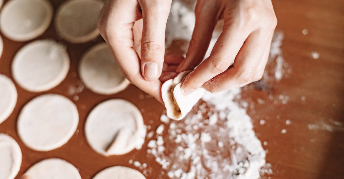 Stuffed Dumpling Made with Rice Flour - Person Holding Flat Dough with Flour