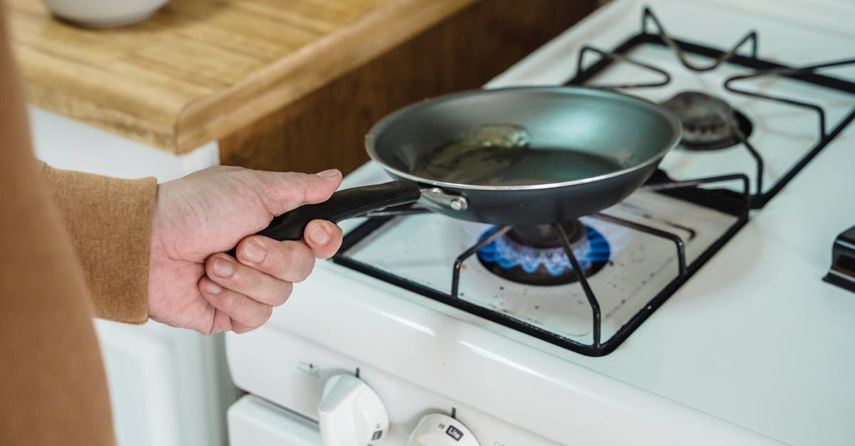 Stuffed pumpkin on a burner - Person Holding Black Frying Pan