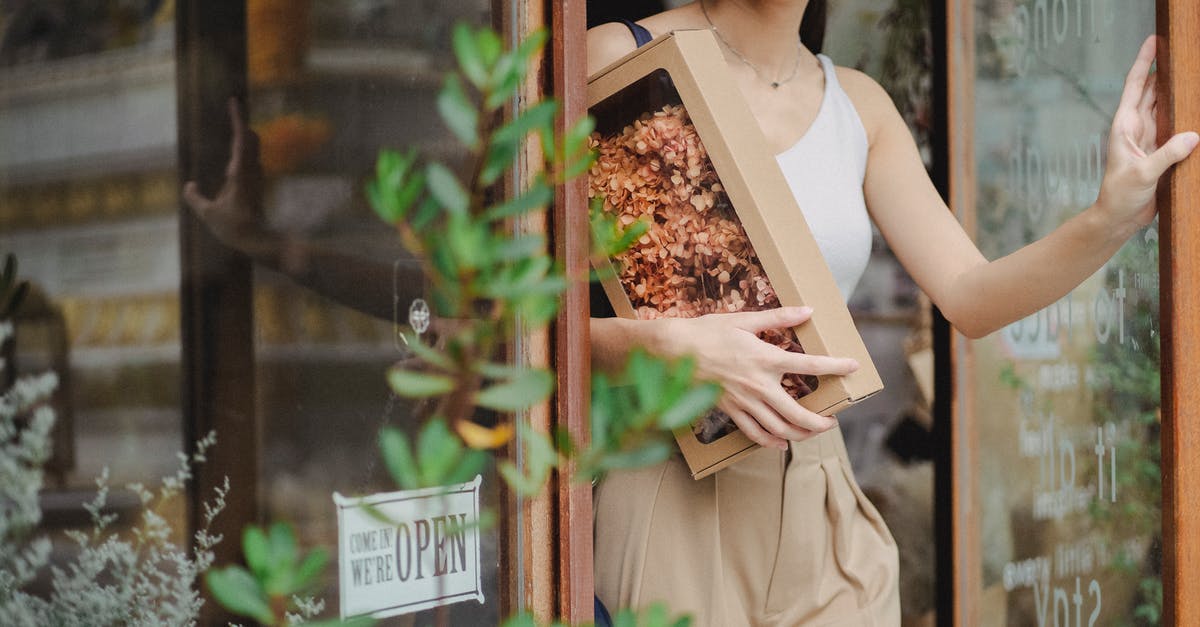 Substitute dried pig's blood for fresh - Crop glad woman with dried flowers box leaving floristry store