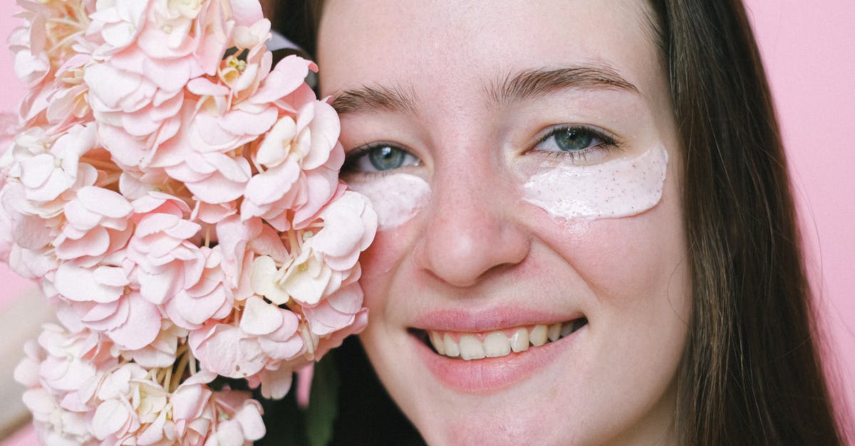 Substituting cream of tartar in turkish delights? - Crop positive young female model with eyes mask smiling at camera while demonstrating hydrangea flower on pink background